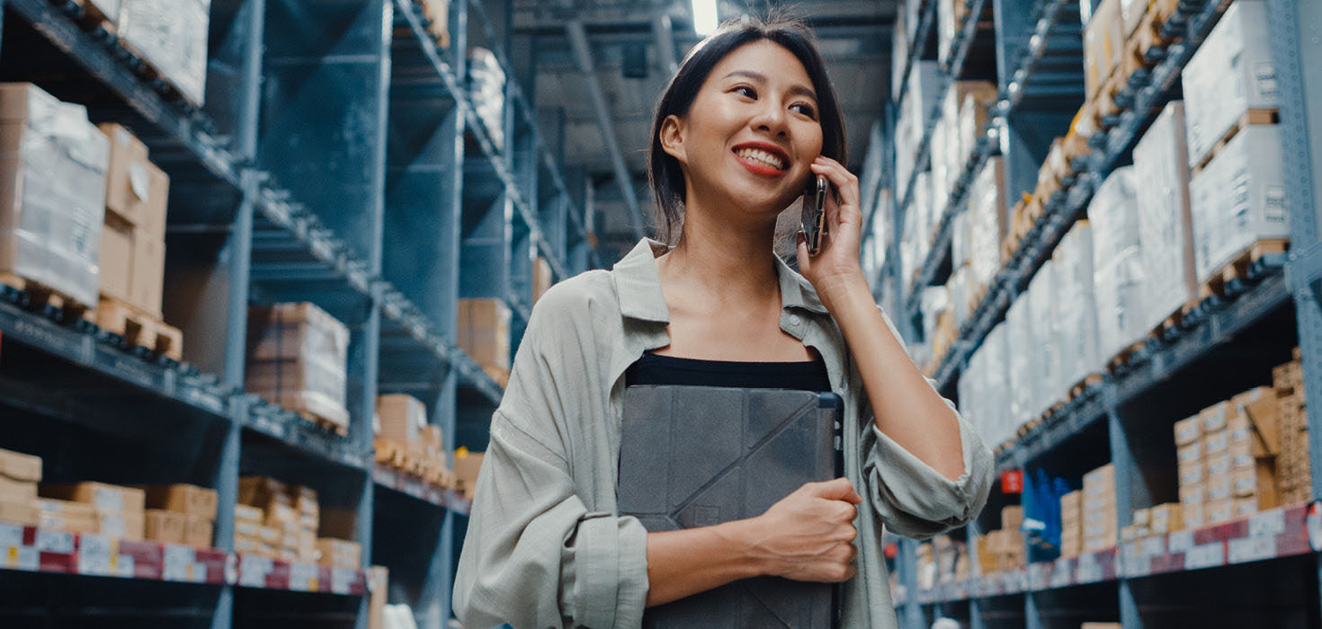 Smiling warehouse worker on her phone