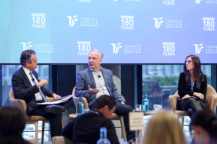 Three speakers on a stage in discussion
