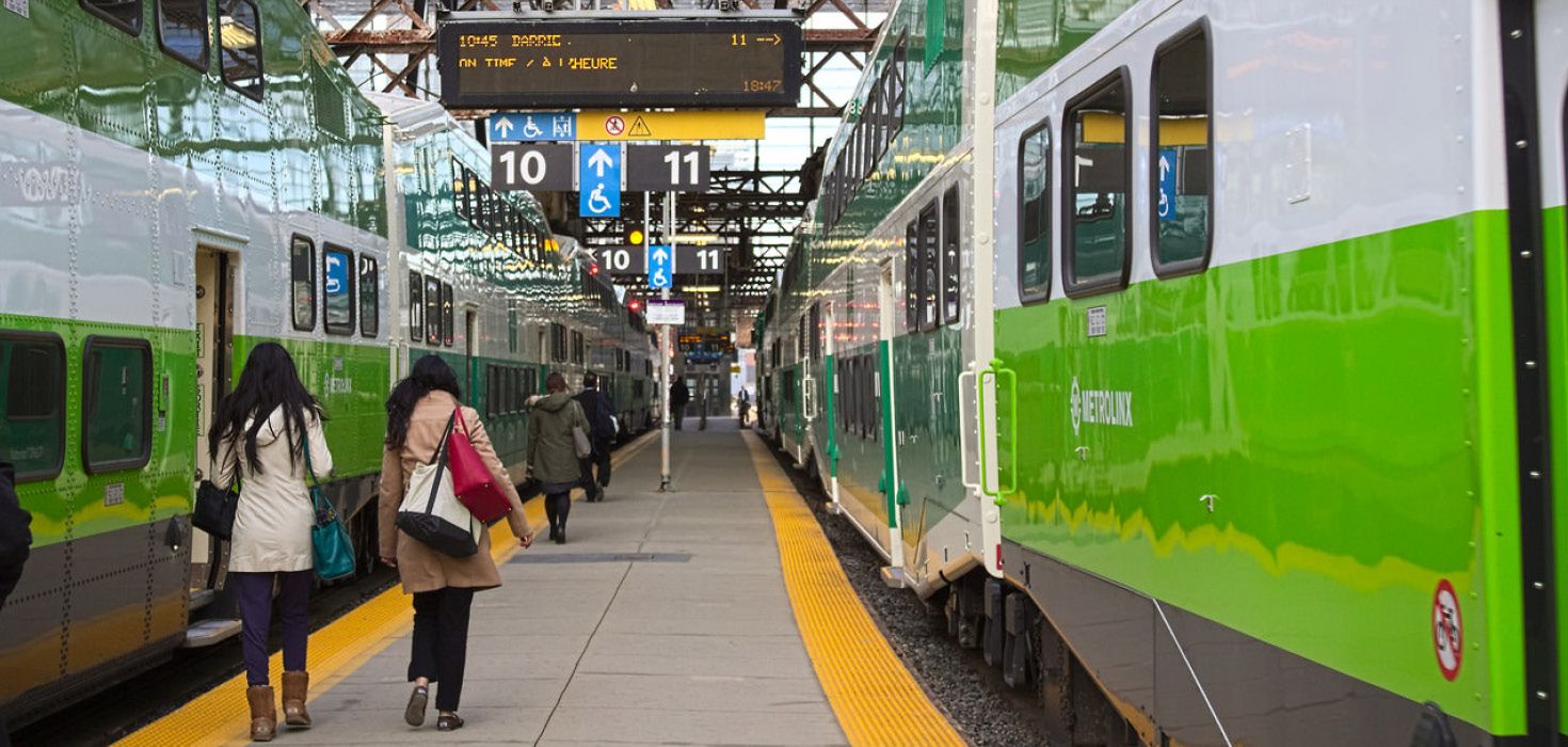 Transit riders walking beside a GO train