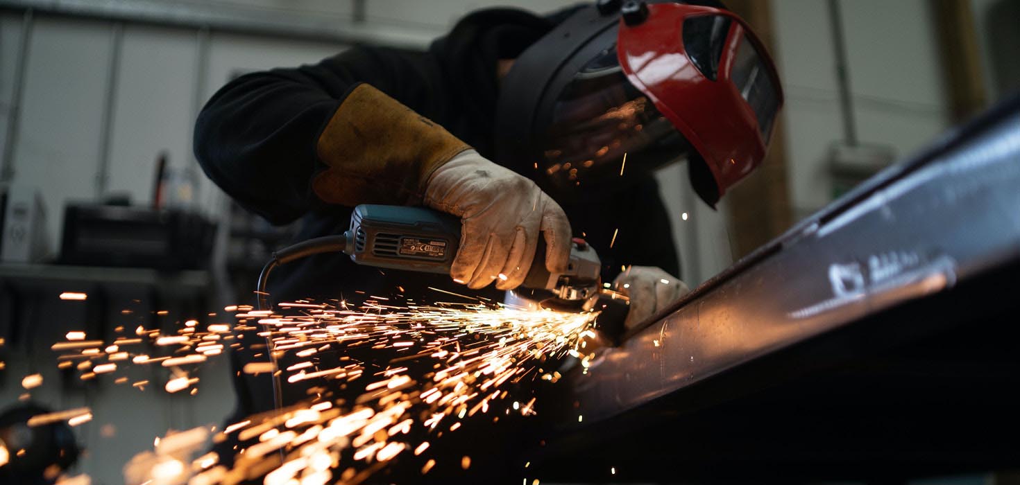 Guy cutting something, sparks are flying