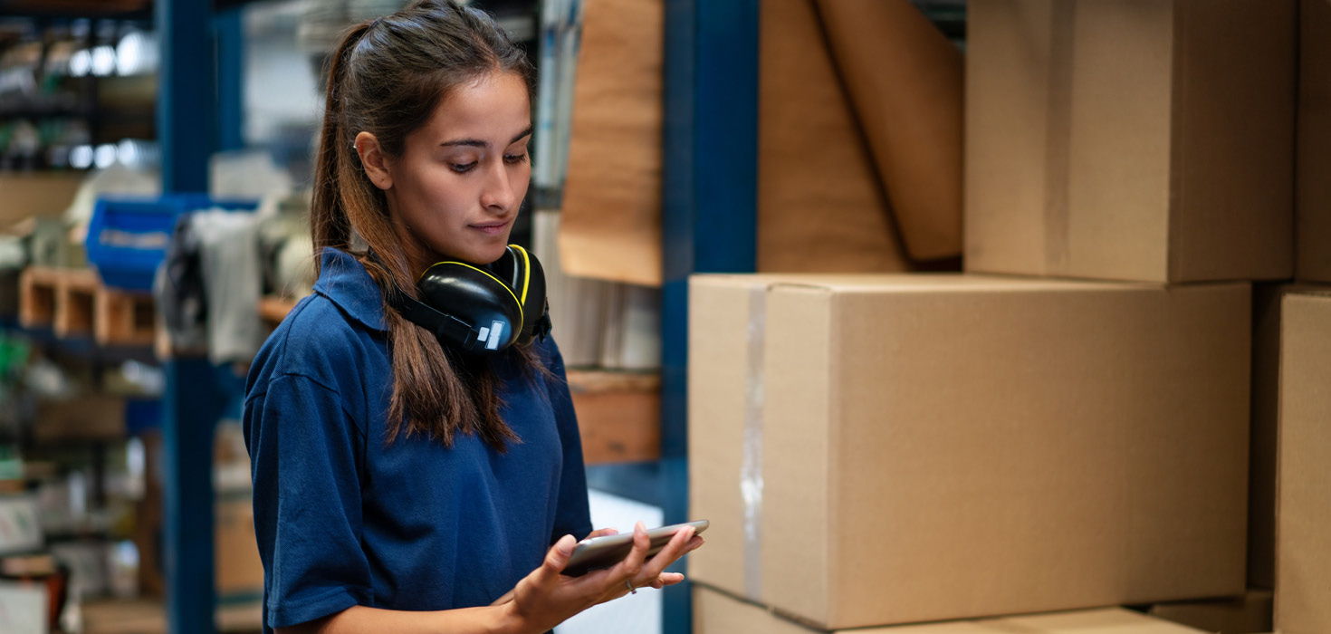 Female warehouse worker tracking inventories with a tablet.