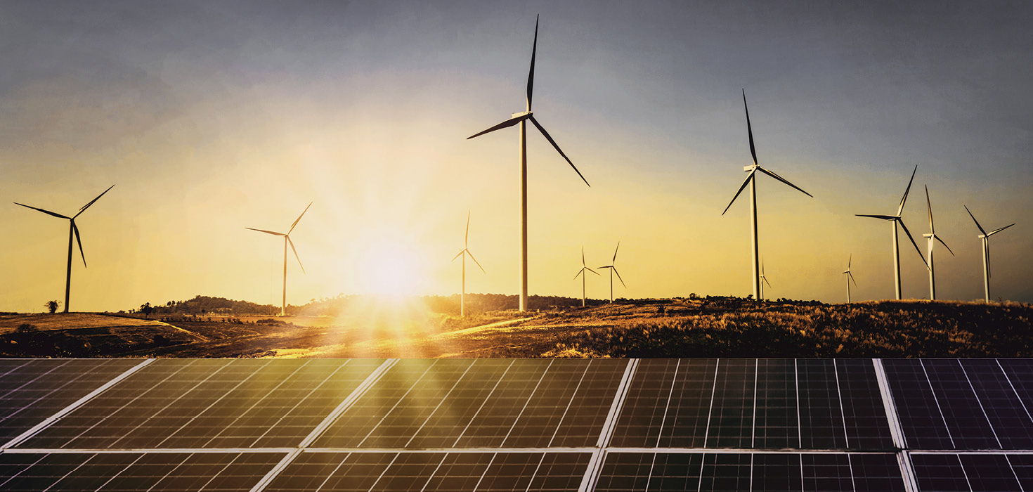 Several wind turbines in a misty, sunlit field.