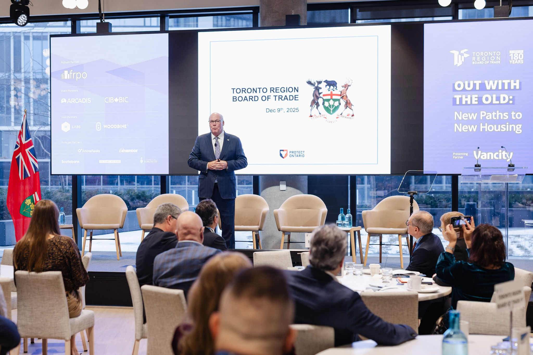 A man stands on stage speaking to the audience