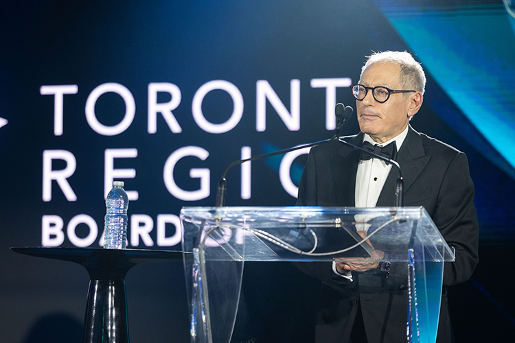 Giles Gershon speaking at a podium