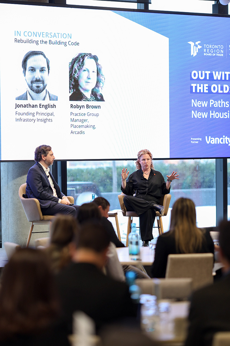 Speakers sit on a stage