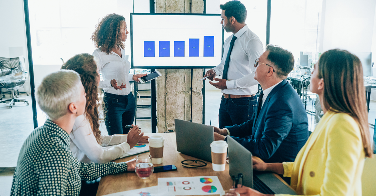 A group of people working together, looking at a presentation.