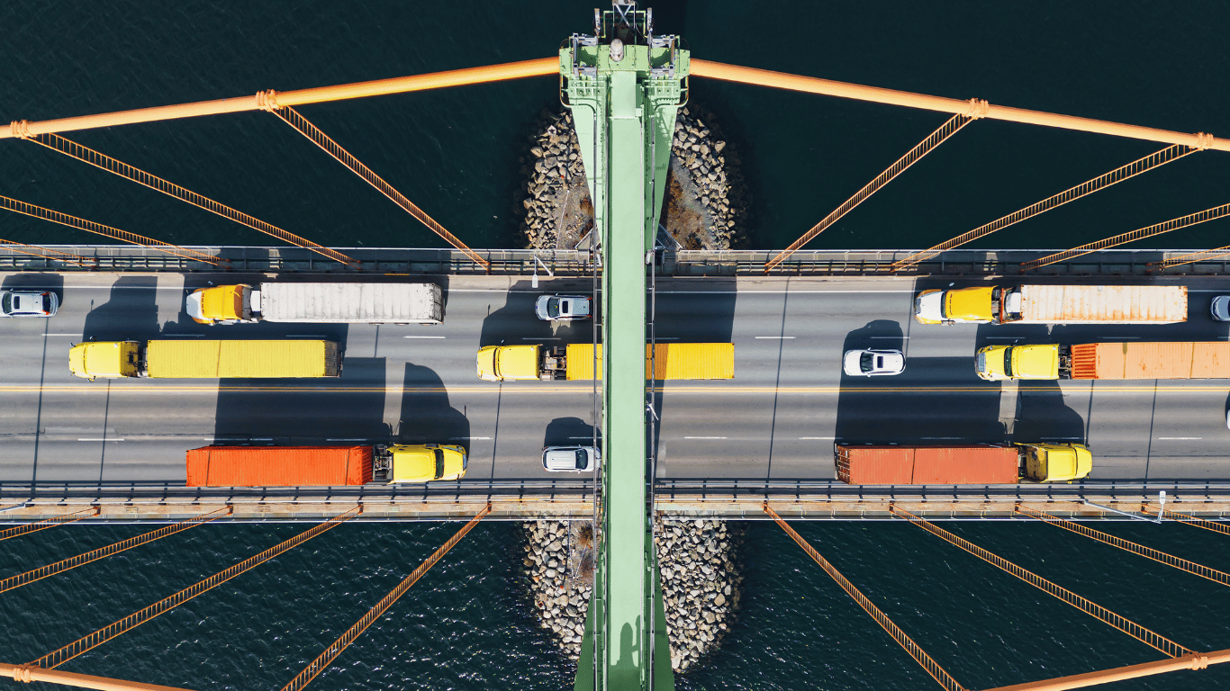 Birds-eye view of transport trucks on a bridge