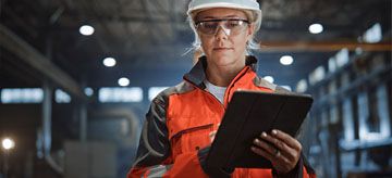 A woman holding a clipboard in an industrial centre.