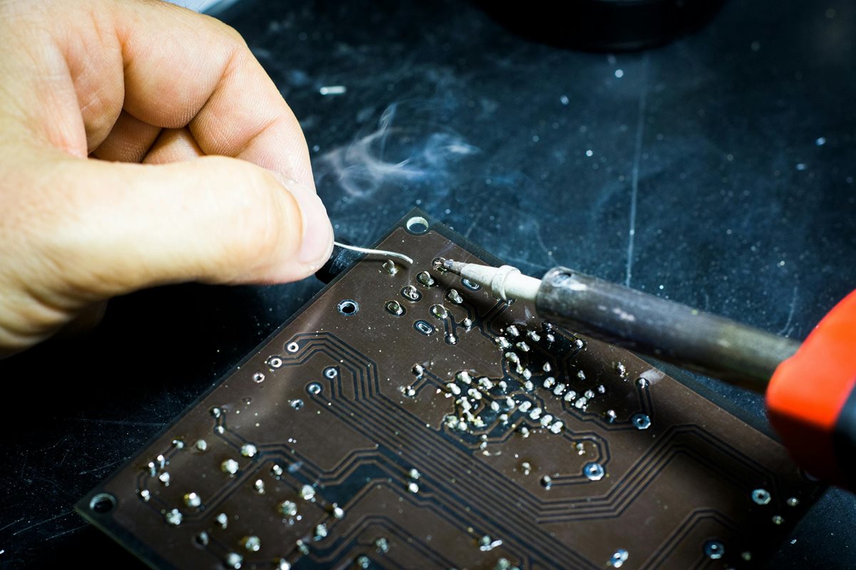 A person working on soldering a circuit board.