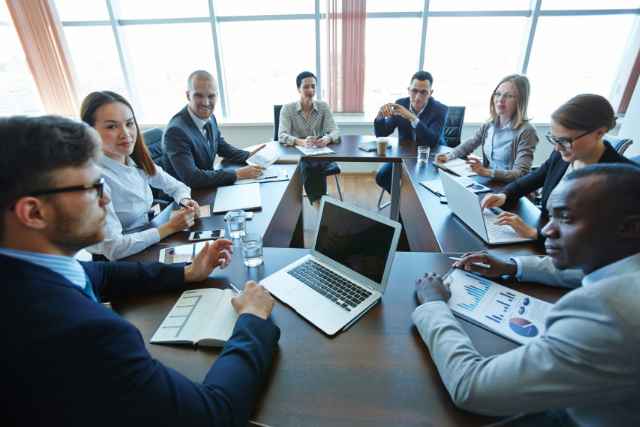 group discuss charts on a laptop