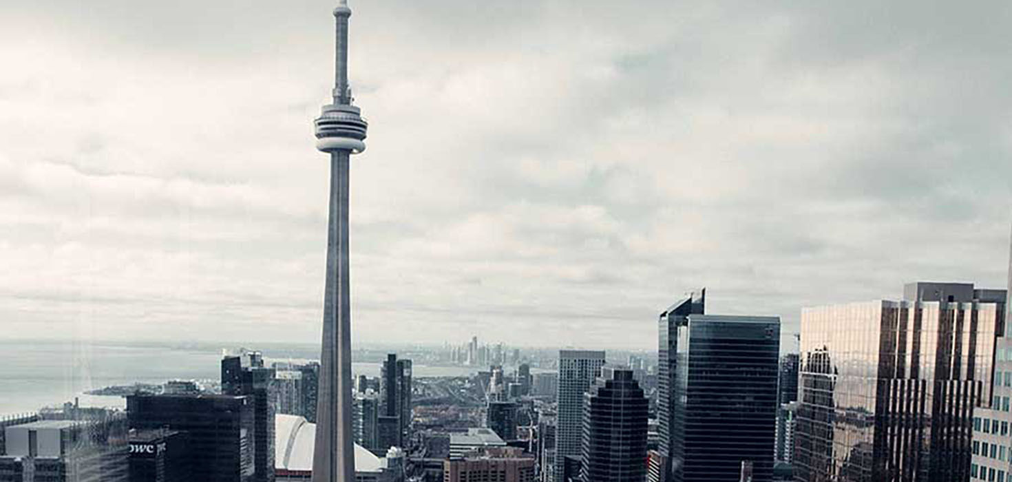 Skyline of Toronto on a cloudy day, with the CN Tower prominently visible.