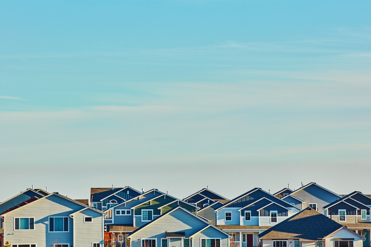 Blue sky above a flock of single-family homes.