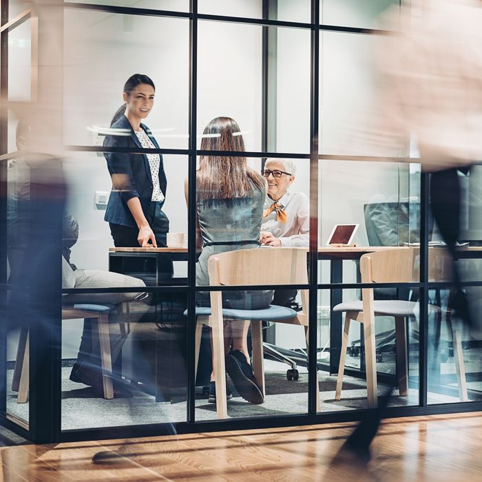 People working together in a glass room.