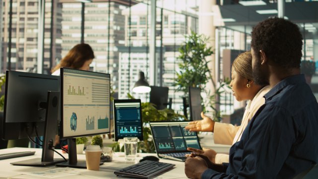 Colleagues discuss data at a computer