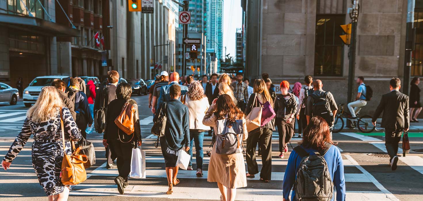 People walking in a downtown crosswalk in Toronto.
