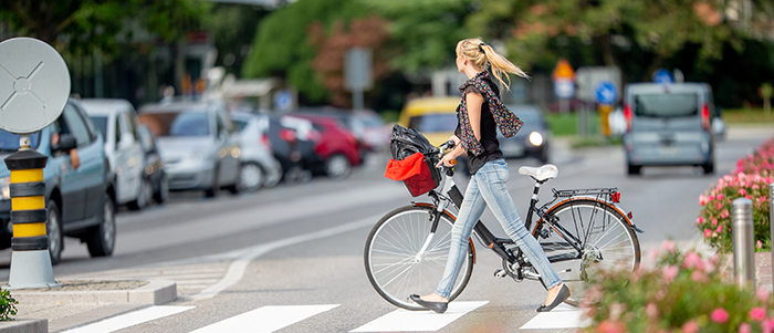 Women guiding a bicycle through a crosswalk