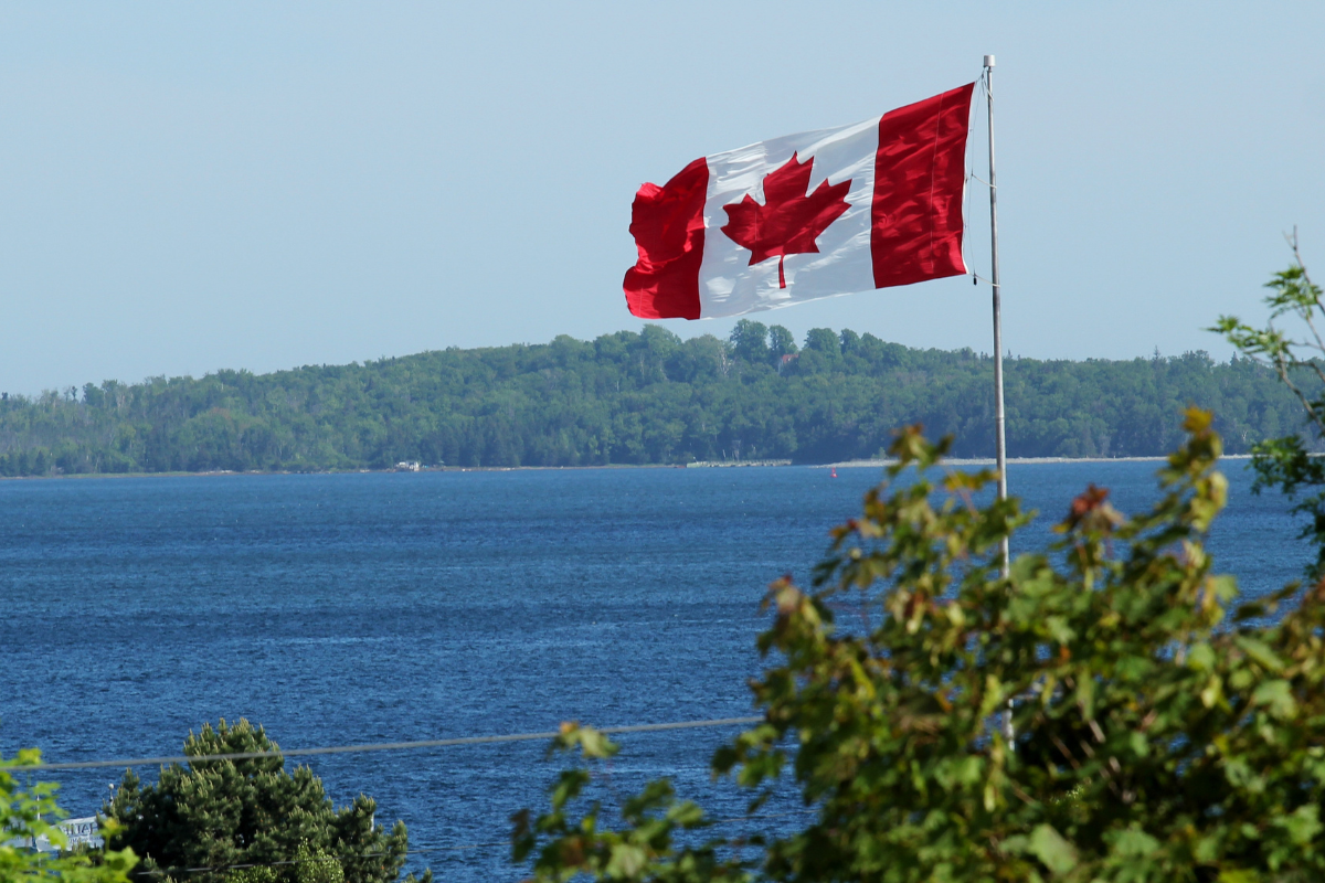 A large Canadian flag flying over cottage country in Ontario.