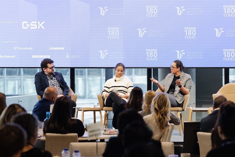 Three people sit on stage at a TRBOT event