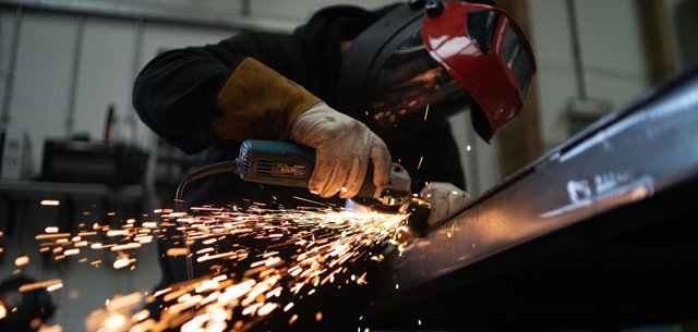 Guy cutting something, sparks are flying