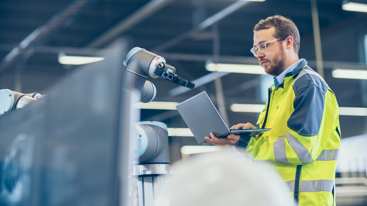 An engineer with a laptop working on a product.