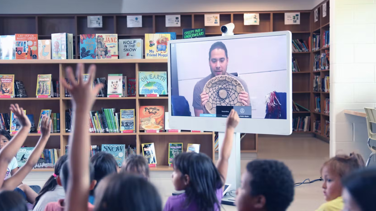 Students in a classroom raise their hand to answer a question.